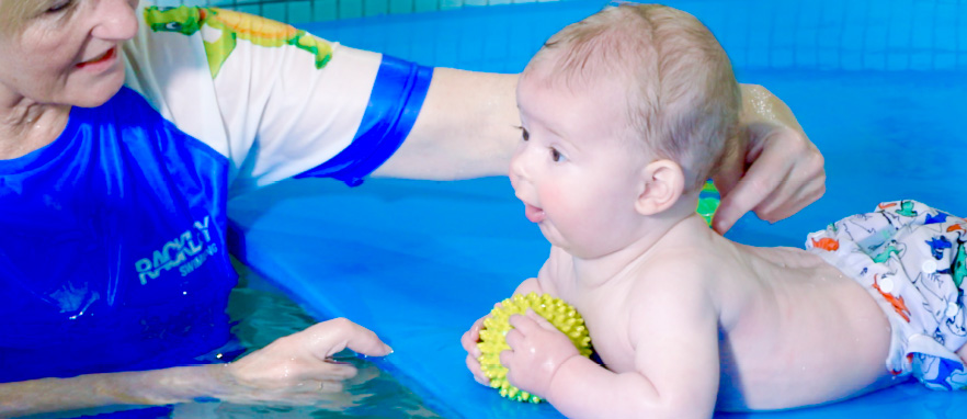 woman teaching baby to use its arms in pool
