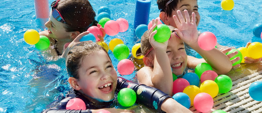 children playing in a swimming pool with coloured balls